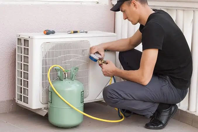 Technician checking refrigerant equipment on an outdoor cooling unit